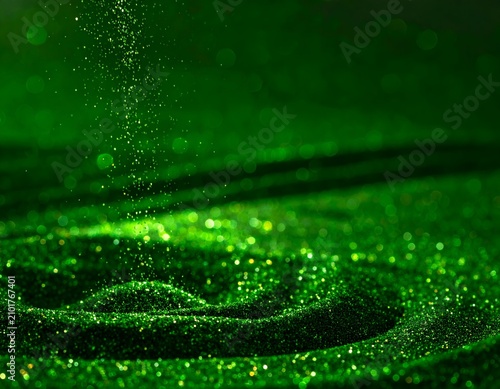 Sparkling green glitter cascades, forming concentric circles against a dark background