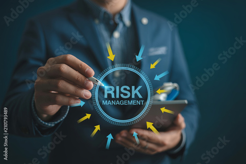 Businessman holding tablet with circular risk management dashboard and directional arrows.