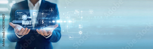 Fotografie Financial auditor handhold virtual screen for Audit compliance while working on laptop to verify records