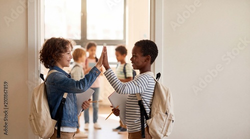 Back to School: two happy elementary students with backpacks high-five in a classroom doorway, celebrating the first day of school and learning
