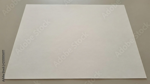 A photograph shows a white rectangular object on a beige surface indoors.