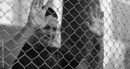 Canvastavla Latin Hispanic man of African descent striking fence in anger and frustration, e