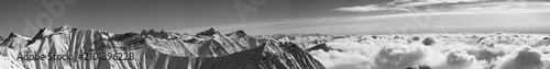 Panorama of snowy mountains covered with clouds at winter