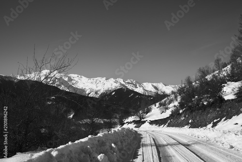 Ice-covered road in winter snow mountain at sun cold morning