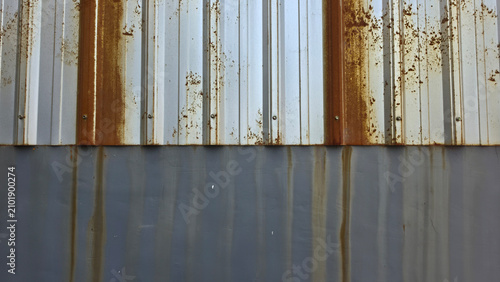 Foto Weathered rusty iron fence above a gray concrete wall, with orange corrosion stains streaking down the surface, creating an industrial grunge texture for decay, aging, and urban background concepts