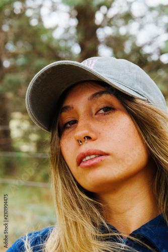 Konstfotografi portrait of a young cute latino brunette girl with a baseball cap glancing sidew