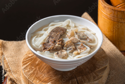 Obraz na plátně Hearty Noodle Soup: A warm and inviting bowl of noodle soup filled with tender slices of beef and plump dumplings, perfect for a comforting meal