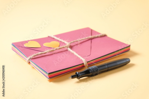 A Stack of Color envelopes tie with hemp rope on background.