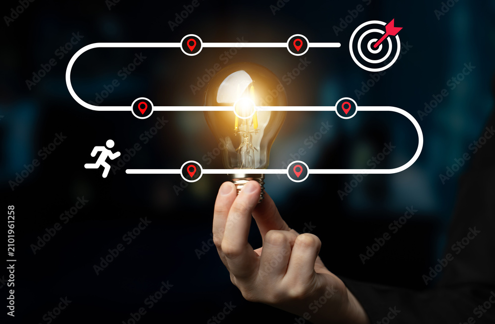 Fototapeta premium This image illustrates a vibrant concept of journey towards achievement, showcasing a light bulb representing ideas, progress, and the target for successful goal completion. Ledger