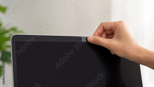 Hand Closes A Physical Webcam Cover On A Blank Laptop