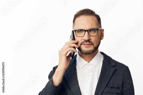 Cuadro en lienzo Businessman on a colored isolated backdrop, speaking on a mobile phone with a calm, confident expression