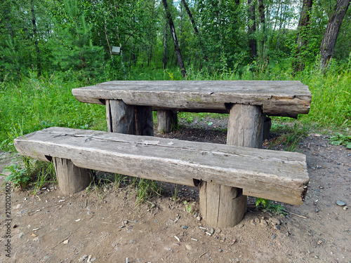 Rustic picnic set consists of a table and benches made from solid logs.