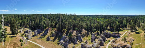 Foto Luftaufnahme des Felsenmeers im Wental mit markanten Felsformationen aus Jurakalk, umgeben von einem dichten Nadelwald und Wanderwegen auf der Schwäbischen Alb bei Sonnenschein