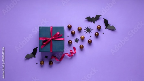 Halloween gift box with bats and gold ornaments on purple background