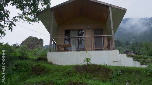 Wooden cabin on misty green hillside