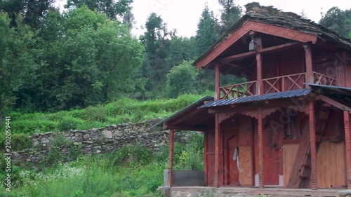 Rustic wooden cabin in green forest landscape
