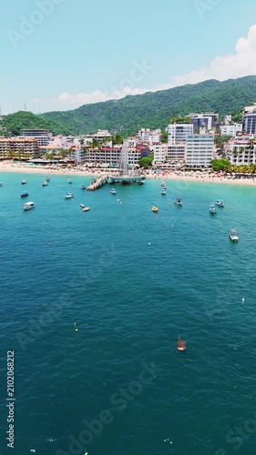 Drone rotating over los muertos beach with the pier standing out in puerto vallarta mexico