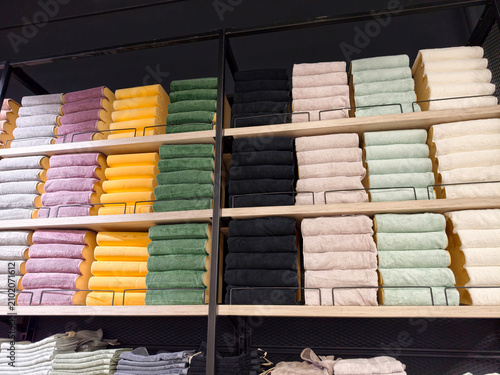 Vászonkép Bright multicolored towels stacked on big shelves in superstore