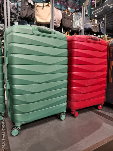 Large rolling suitcases neatly displayed on shelves in a hypermarket