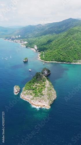 Drone shot flying over the iconic rock formations of los arcos in puerto vallarta mexico