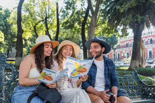 portrait of young latin friends traveling holding a tourist map in Mexico Latin America, hispanic people tourist in colonial city 