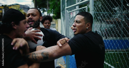Quadro em tela Two Hispanic men argue intensely outside in street, shouting and pushing as emot