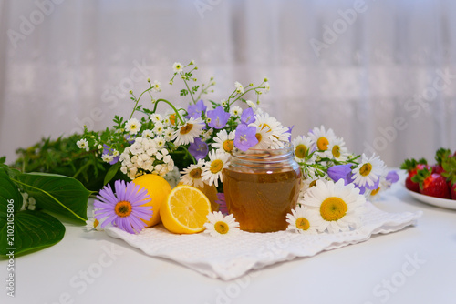 Natural honey is often enjoyed with warm tea and lemon during the cold season. The golden sweetness and fresh citrus create a cozy, healthy food composition with summer flowers.