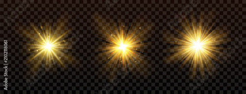 Obraz na plátně Golden Burst of Light: Three radiant golden starbursts with sparkling particles explode against a dark, transparent background, evoking energy and brilliance