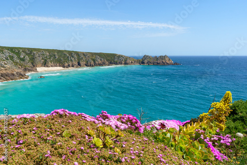 Coastal landscape with turquoise water and rocky cliffs in Cornwall, UK.