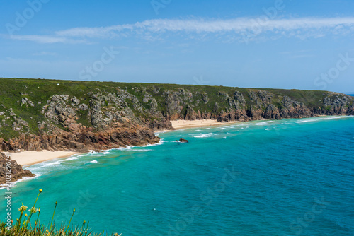Coastal landscape with turquoise water and rocky cliffs in Cornwall, UK.