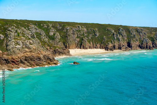 Coastal landscape with turquoise water and rocky cliffs in Cornwall, UK.