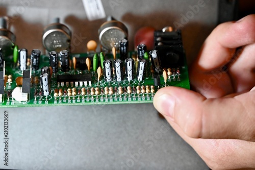 Cuadro en lienzo Technician hands installing preamp circuit board of a bass guitar amplifier clos