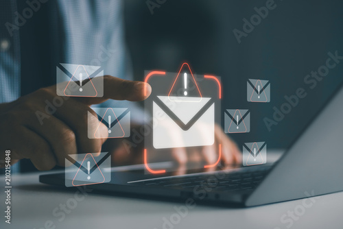 Obraz na płótnie Cybersecurity concept showing phishing email alert icons on laptop screen with businessman hand selecting suspicious message, spam detection, email security, cyber attack prevention, data protection