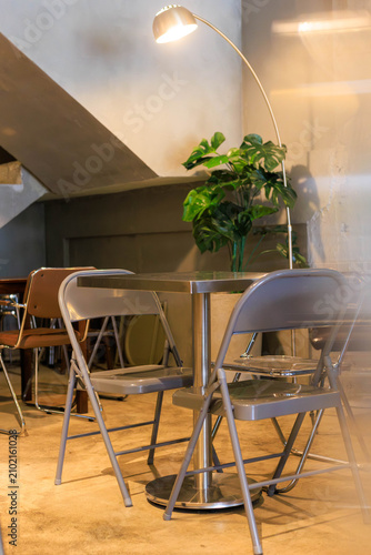 Cozy Cafe Seating Area Beneath Concrete Staircase