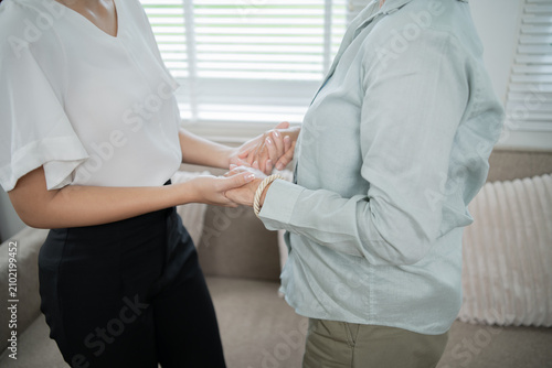 Photography An Asian caregiver gently holds an elderly woman's hand, providing attentive and