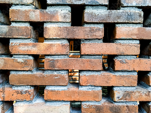 Fotografía Openwork red brick wall forms a geometric ventilation pattern, photographed close up to show rustic masonry, gaps, mortar, and texture