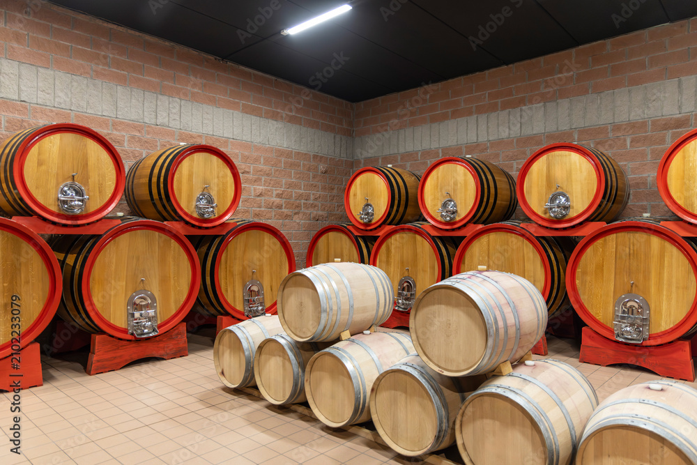 Obraz premium Oak Wine Barrels Aging in a Cellar. Traditional Winemaking Process and Wine Culture Interior, Italy
