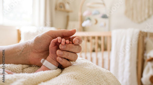 Heartwarming image of a newborn baby holding the hand of first-time parents for maternity and childcare advertising