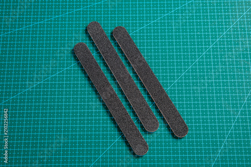 Canvastavla Three black nail files arranged diagonally on green cutting mat for manicure too