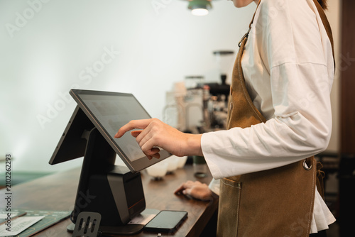 Foto Coffee Shop Barista Using a Touchscreen Point of Sale System at the Counter of a