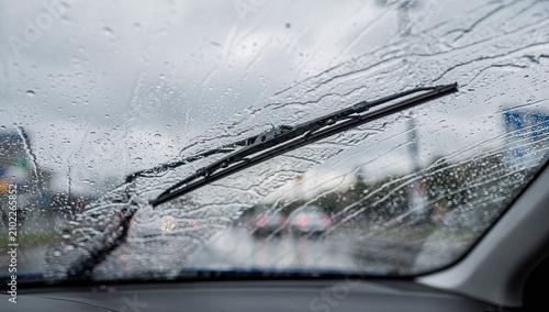 A car windshield covered in raindrops during a rainy day