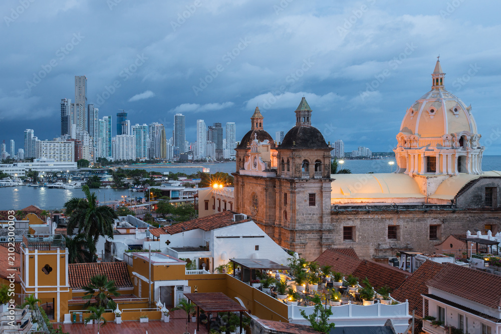 Obraz premium Blue hour view of Cartagena's historic walled city with the Cathedral of Saint Catherine of Alexandria and the modern Bocagrande skyline in the background, Cartagena, Colombia