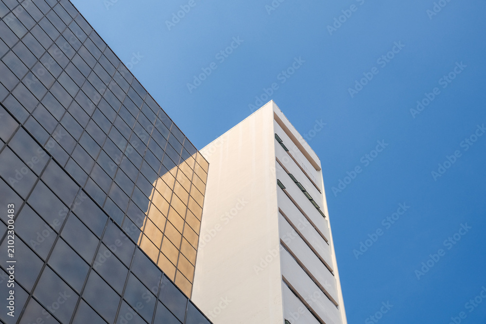 Obraz premium Modern Office Buildings Against Clear Blue Sky with Geometric Architecture