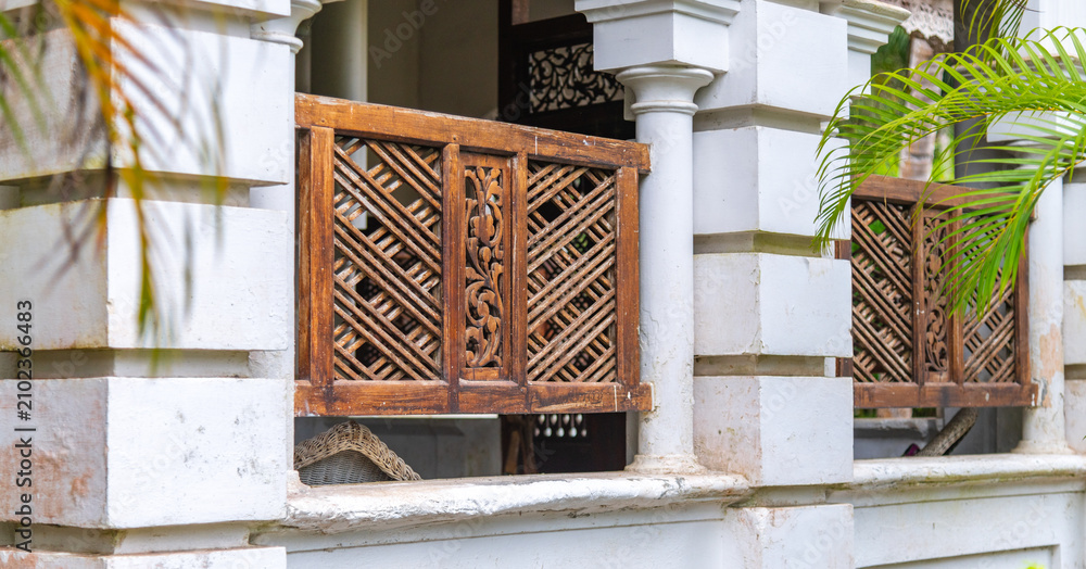 Fototapeta premium Traditional colonial villa window with carved wooden lattice panels