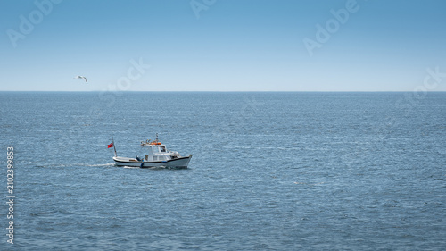 A small fishing boat is sailing in the open sea.
