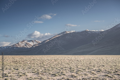 Canvas Print A desert landscape in the highlands of the Pamirs on a sunny summer day with mou