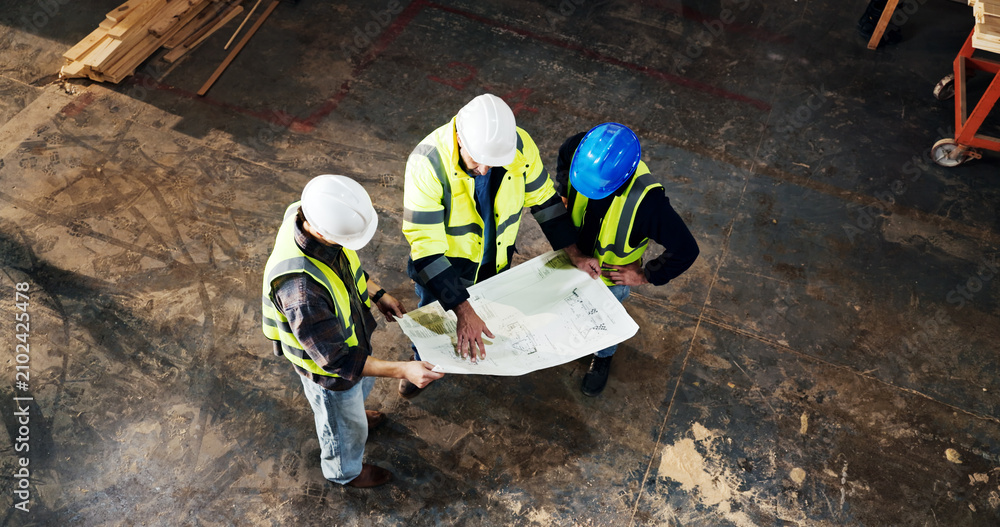Obraz premium Top view, engineer and planning with blueprint at construction site, building development or layout. Architect team, people and discussion with document for infrastructure design, review and above