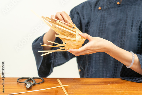 Close-up of female artisan weaving bamboo basket,intangible cultural heritage craft