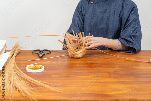 Close-up of female artisan weaving bamboo basket,intangible cultural heritage craft