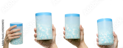 Quadro su tela Hand hold bottle of blue-white penicillin antibiotic capsule pills isolated on white